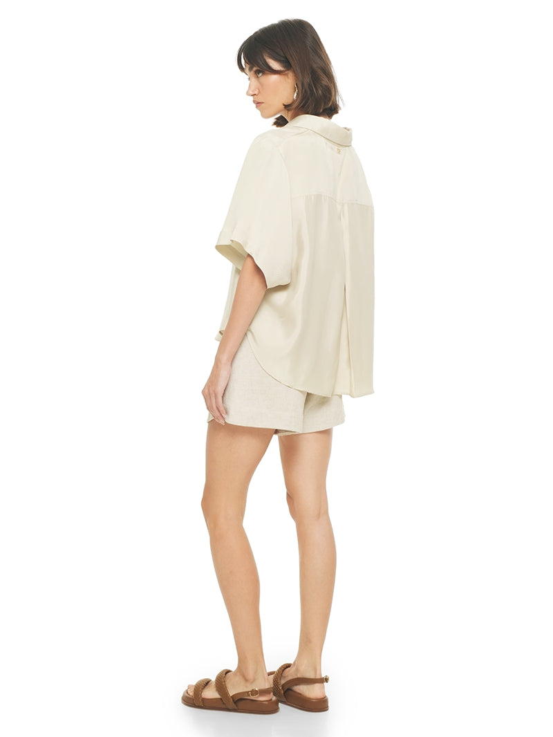 Dian shorts in beige styled with Paris shirt and Charlie flats, back view -worn by model